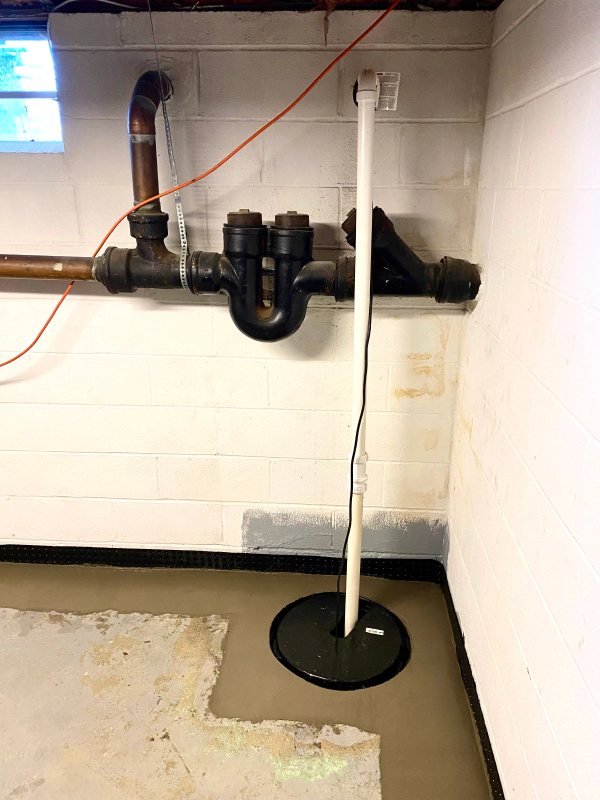 basement pump system in corner of basement